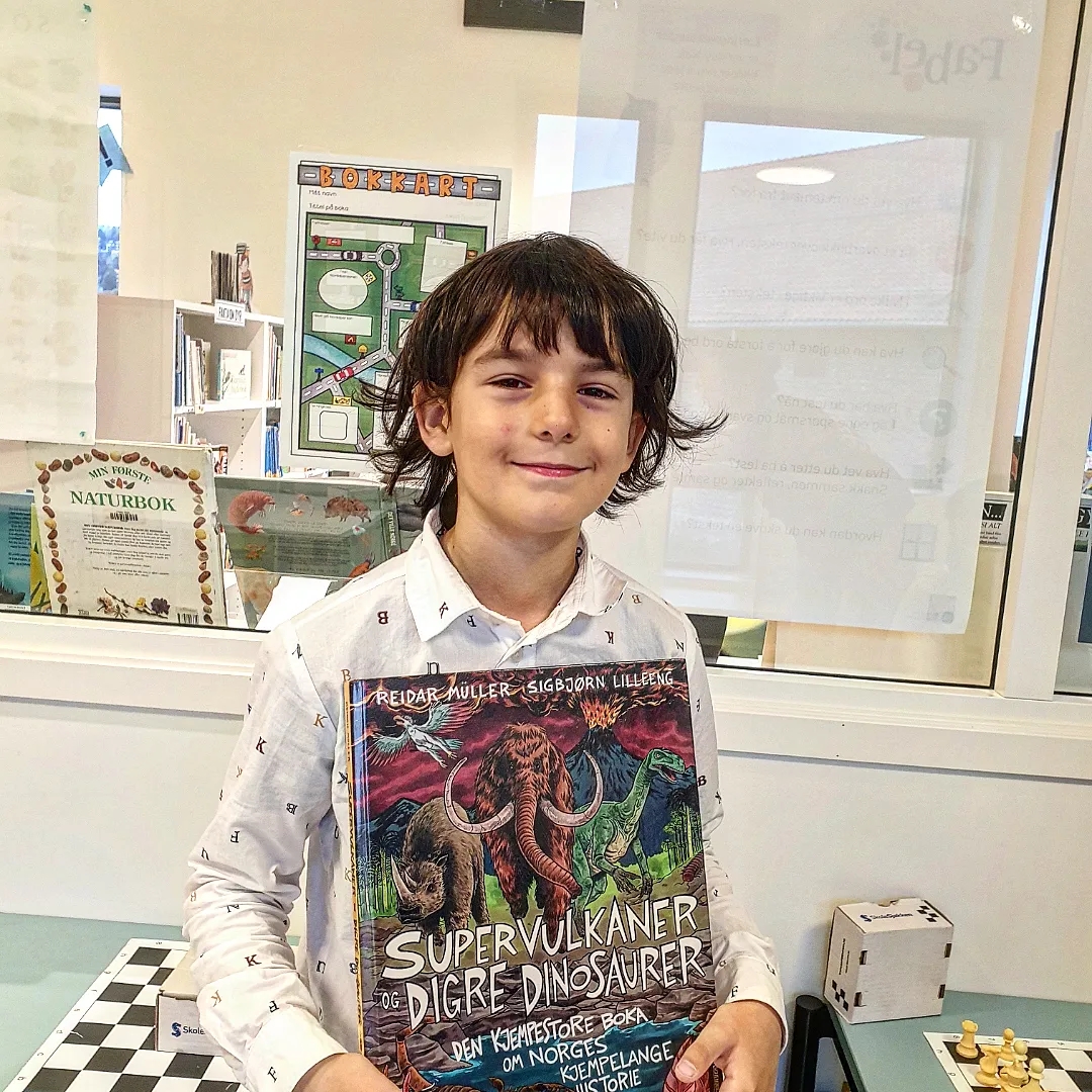 Elev poserer med bibliotek bok