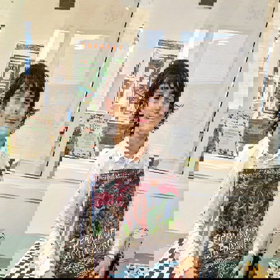 Elev poserer med bibliotek bok